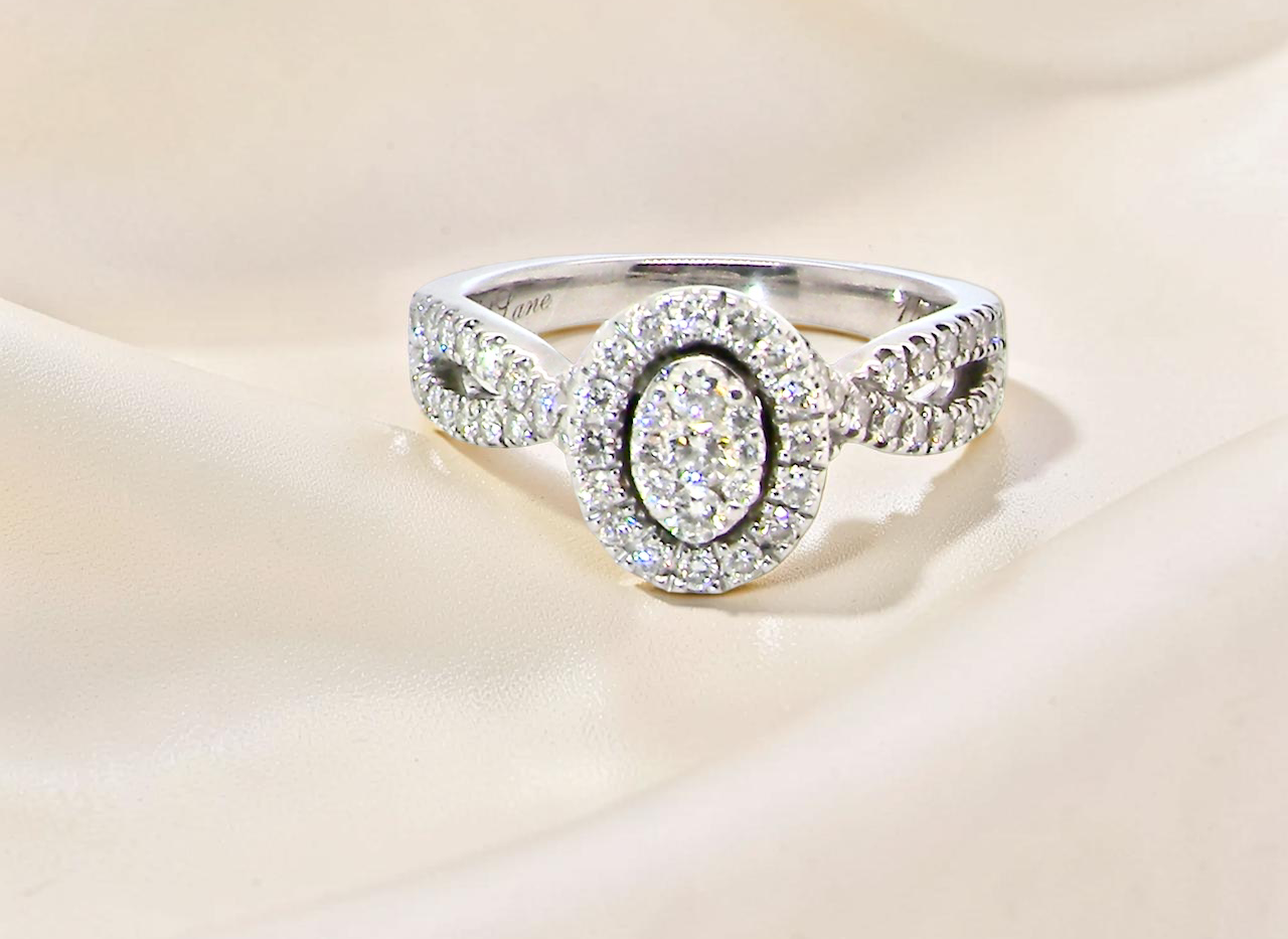 4 carat white gold cluster ring. The centre cluster an oval setting with nine small white diamonds.
Around the outside a halo of sixteen smaller diamonds,
