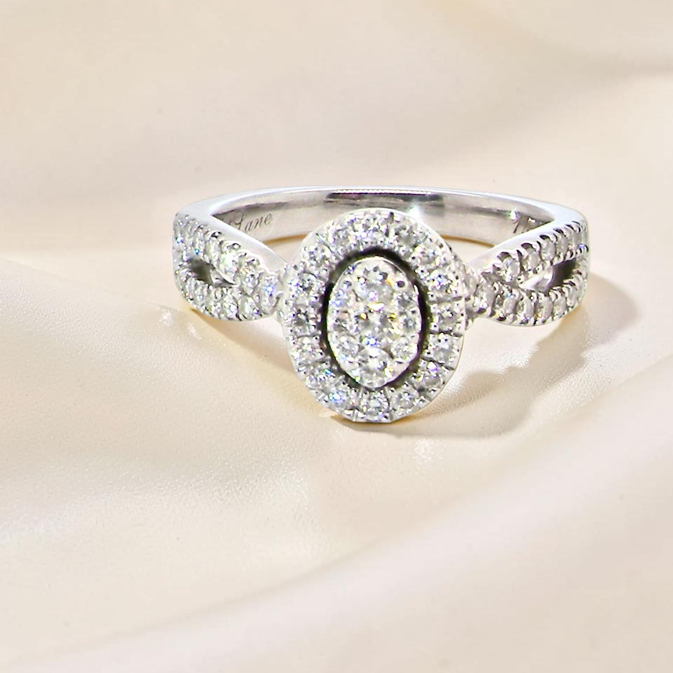 4 carat white gold cluster ring. The centre cluster an oval setting with nine small white diamonds.
Around the outside a halo of sixteen smaller diamonds,