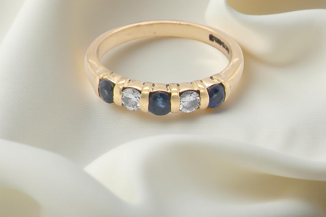 18-carat gold half-hoop eternity ring, set with round mid-blue sapphires