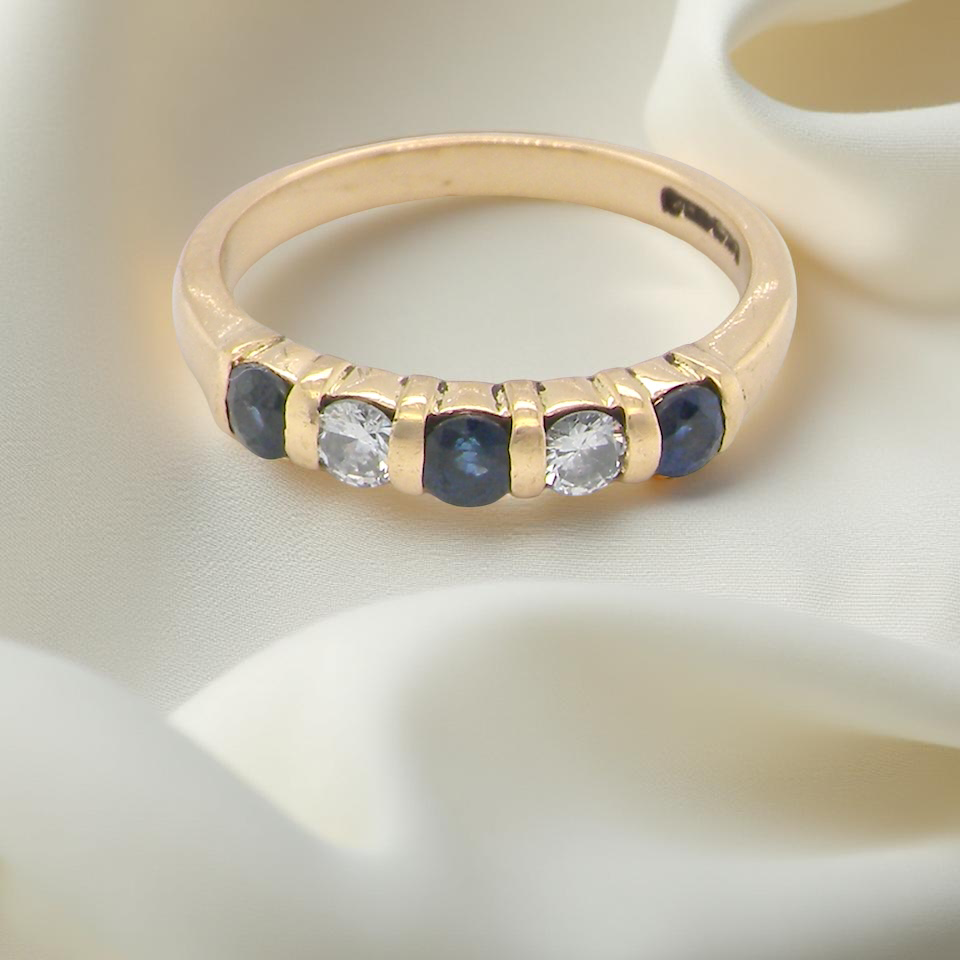 18-carat gold half-hoop eternity ring, set with round mid-blue sapphires