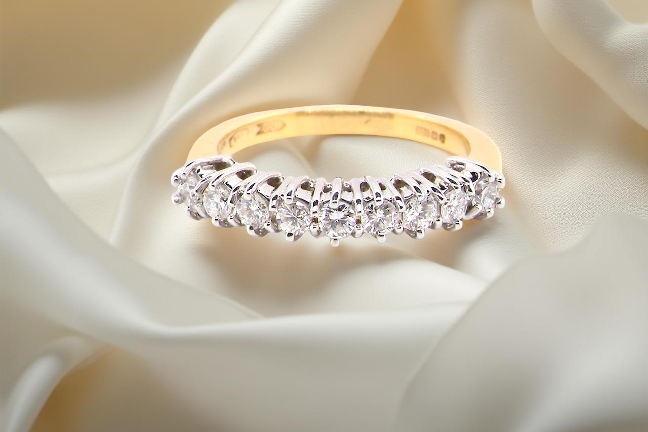 A fine 18 carat gold half hoop eternity ring, beautifully set with an array of seven white diamonds.
