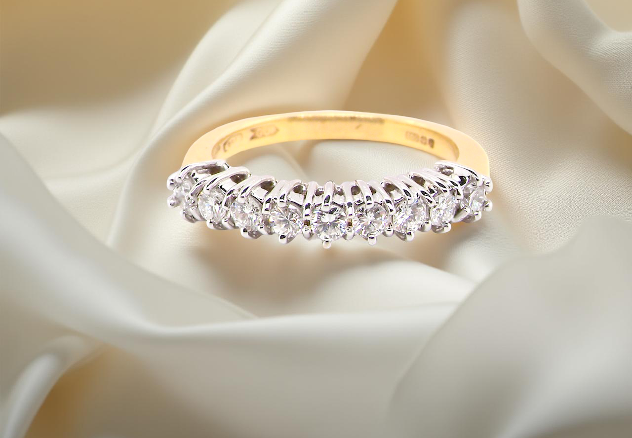 A fine 18 carat gold half hoop eternity ring, beautifully set with an array of seven white diamonds.