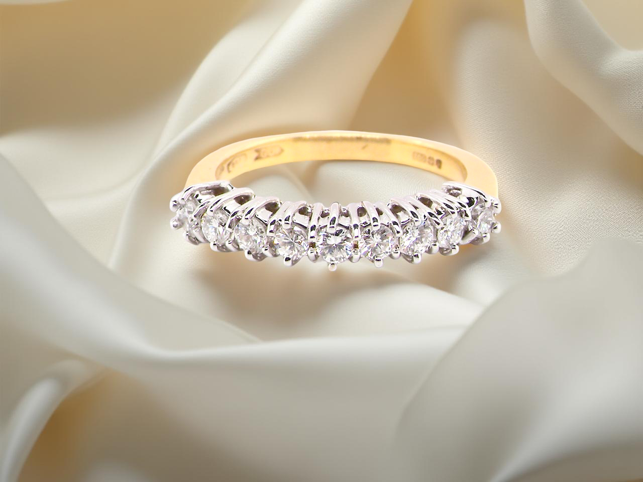 A fine 18 carat gold half hoop eternity ring, beautifully set with an array of seven white diamonds.