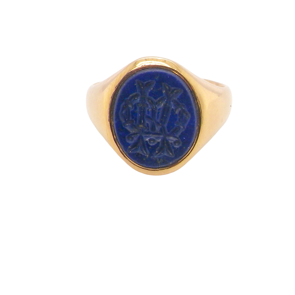 18 carat gold signet ring set with an oval lapis lazuli stone. This measures 12x9.5mm and has a carved intaglio seal engraved onto the stone. (These seem to be floral patterns)