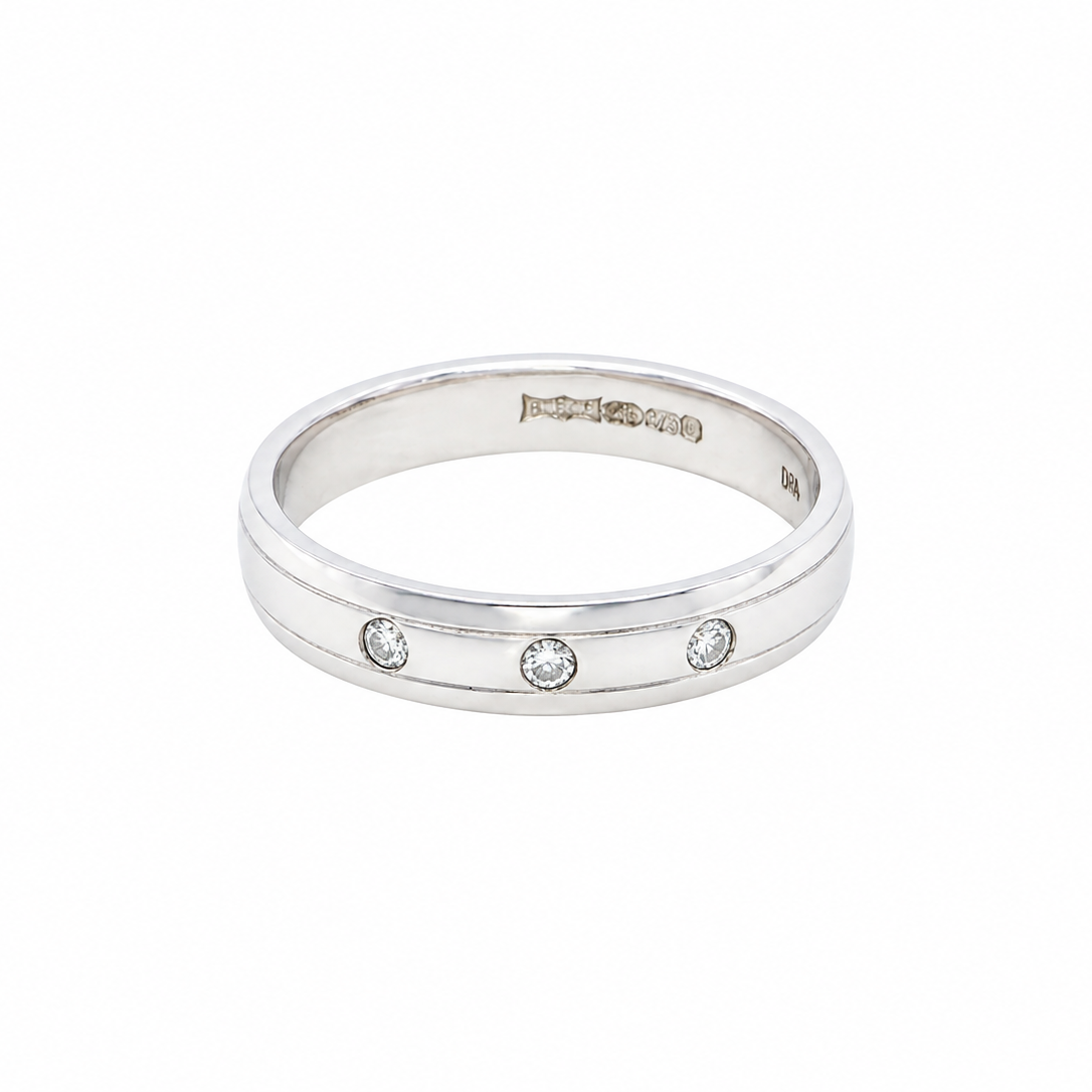 A 9 carat white gold wedding ring. Set with three invisbly set diamonds, each 1.5mm (0.015 carats each).