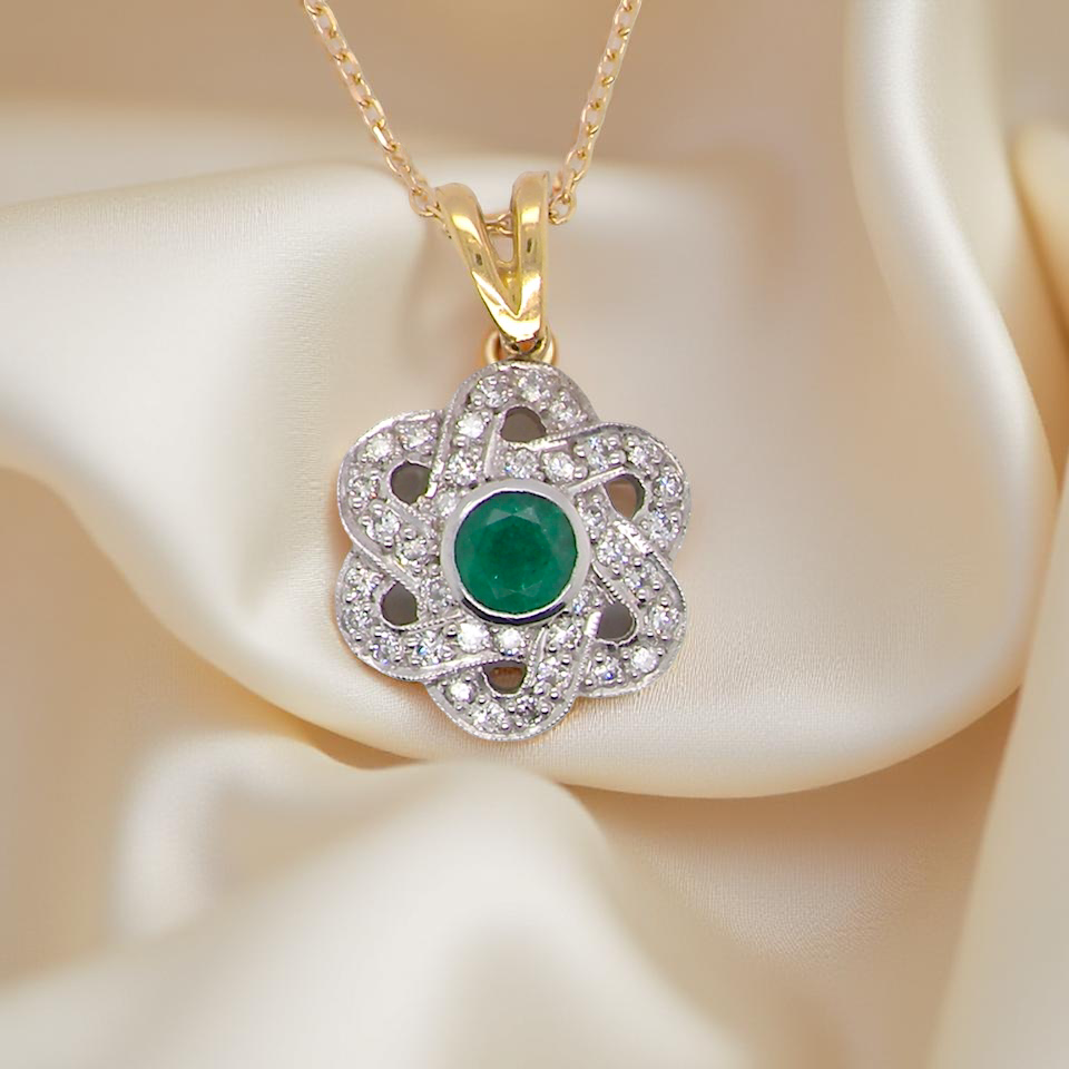 8 carat gold pendant that features to the centre a round emerald A