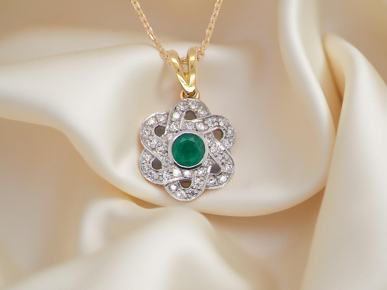 8 carat gold pendant that features to the centre a round emerald A