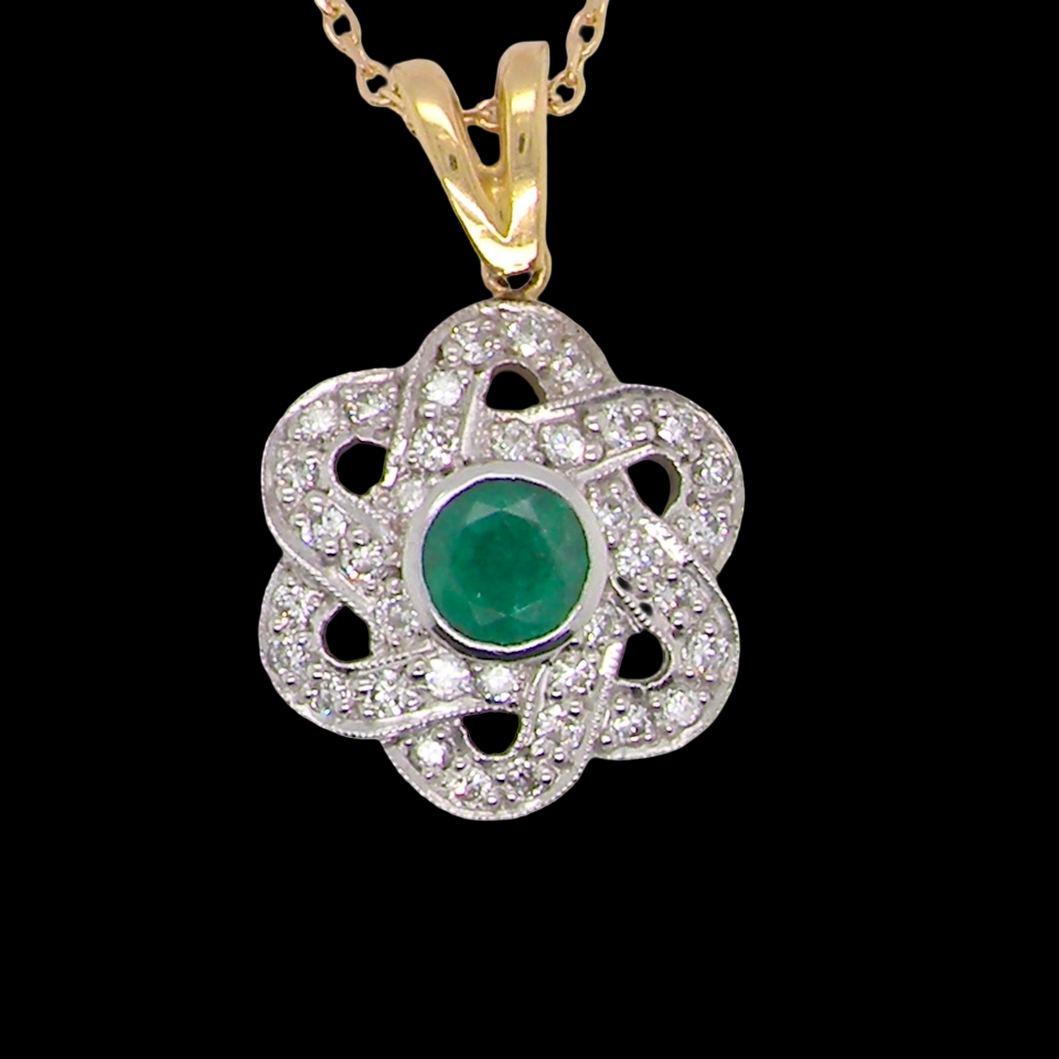8 carat gold pendant that features to the centre a round emerald B