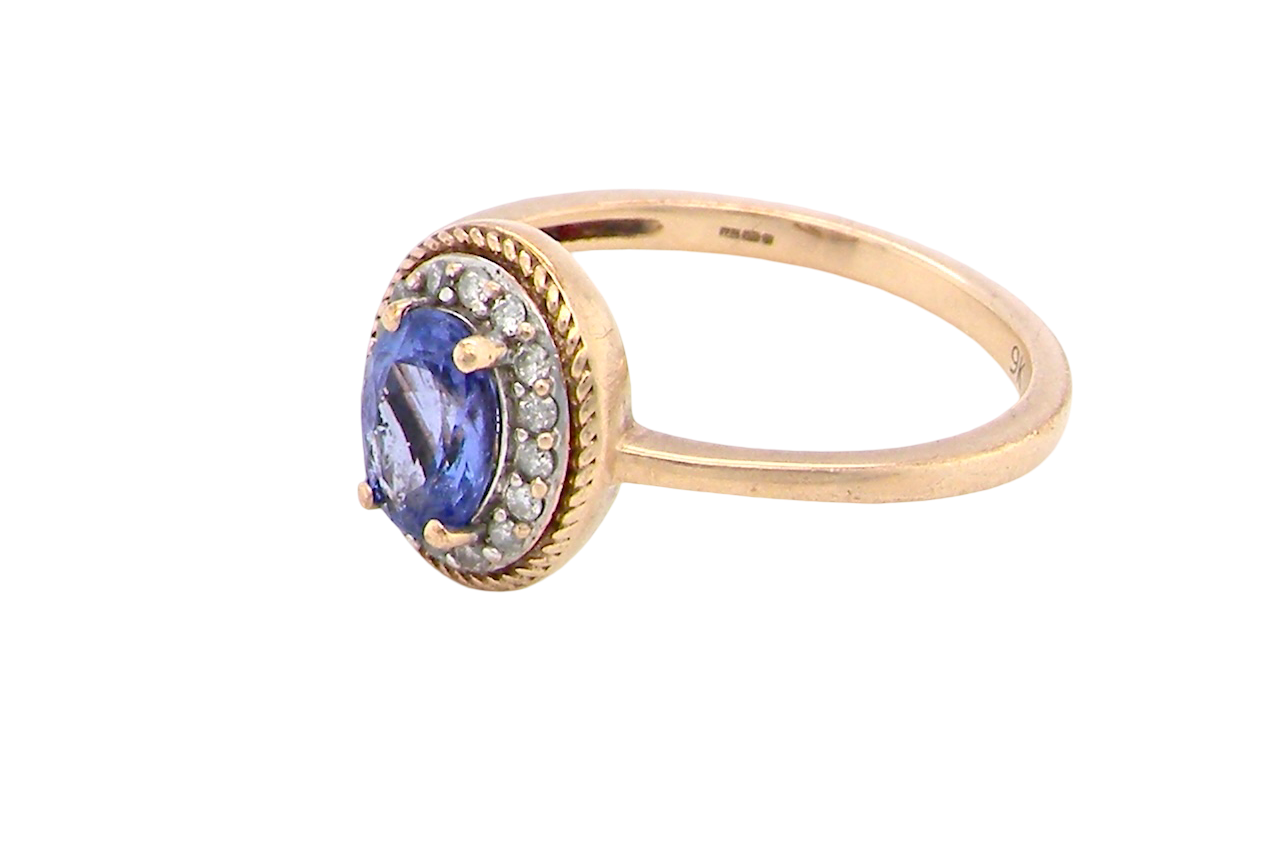 9 carat gold cluster ring. Features to the centre an oval cut tanzanite gem stone. Measures 7x5mm, four claw setting.