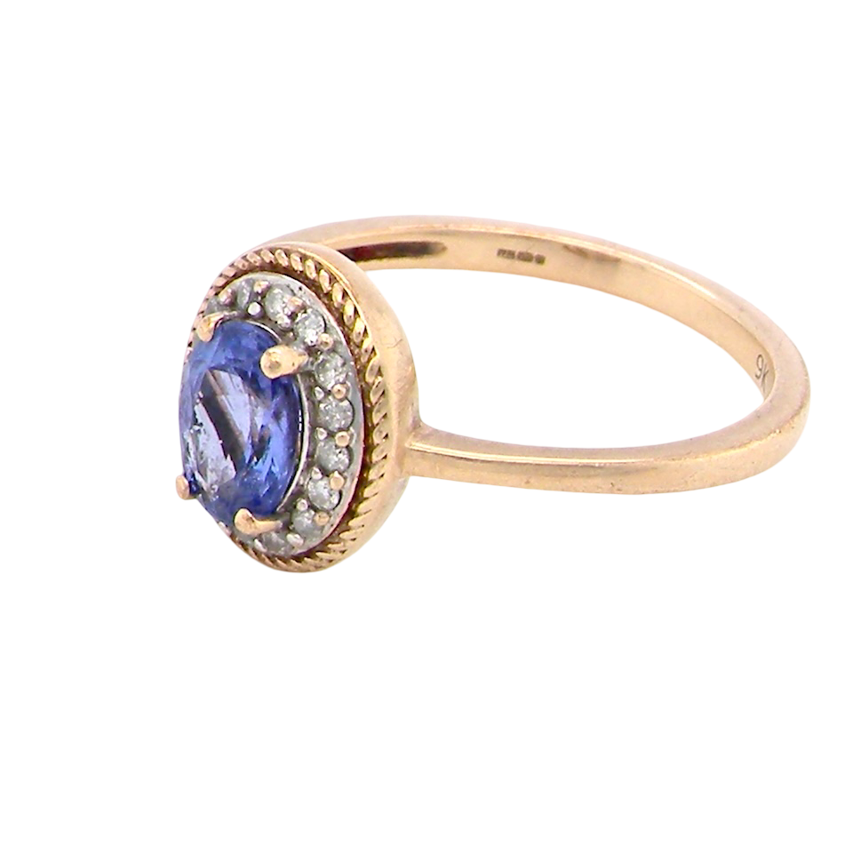 9 carat gold cluster ring. Features to the centre an oval cut tanzanite gem stone. Measures 7x5mm, four claw setting.