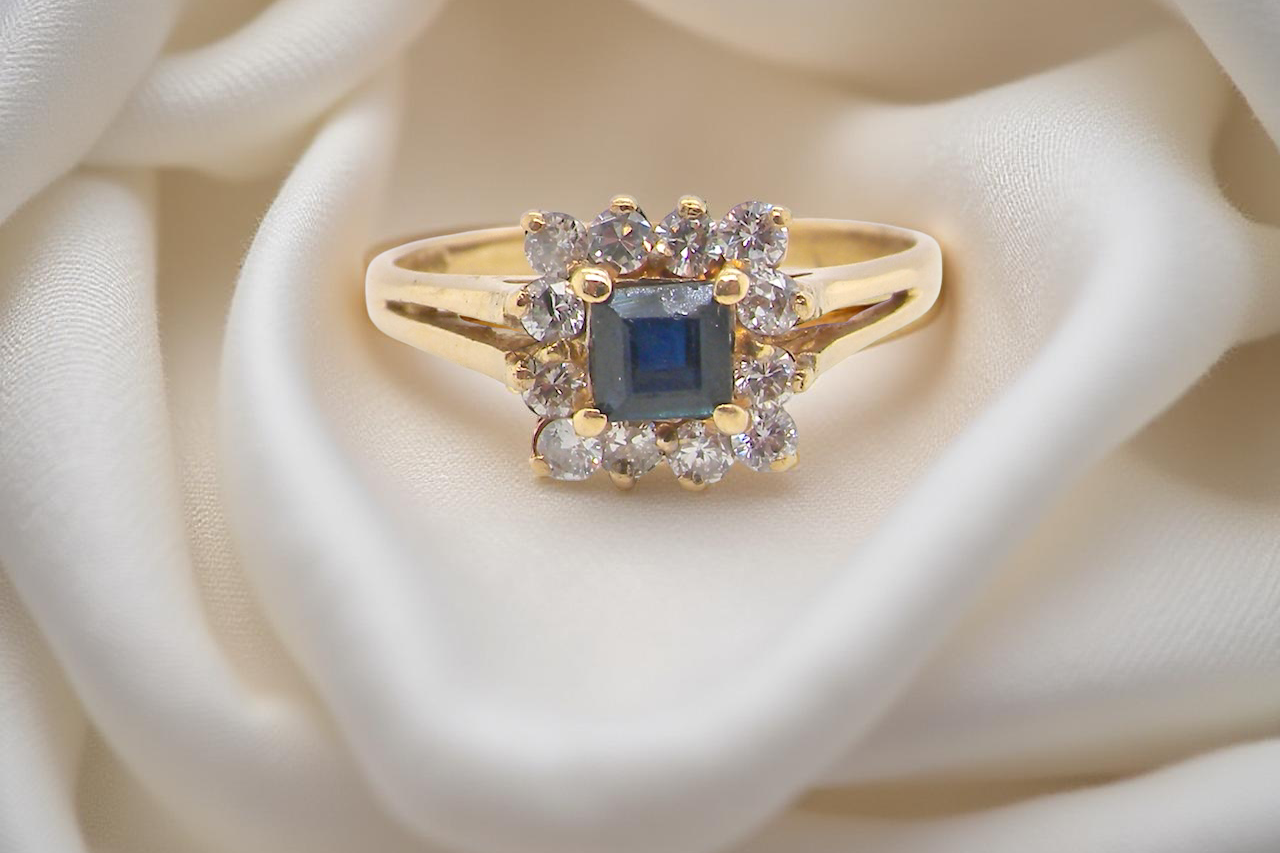 An 18 carat Gold Sapphire and Diamond Cluster Ring (Hallmarked 1997)