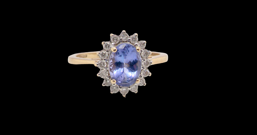 A 14 carat gold cluster ring. Features to the centre an oval cut cornflower blue sapphire, 8x6mm (est 1.25 carats),