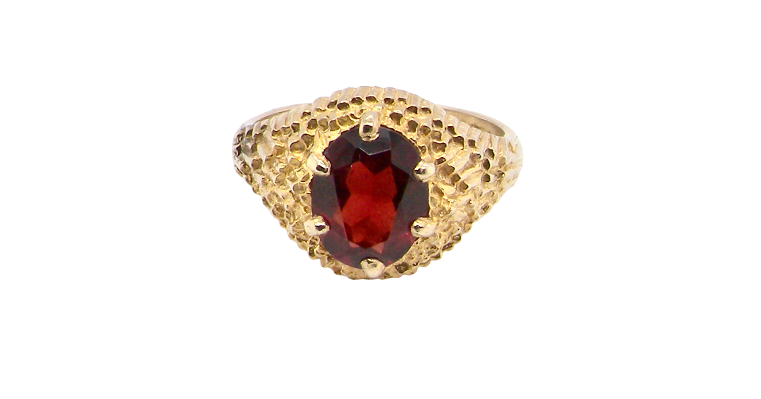 A 1970s dress ring set with an oval garnet stone. This measures 10x8mm and claw set.
