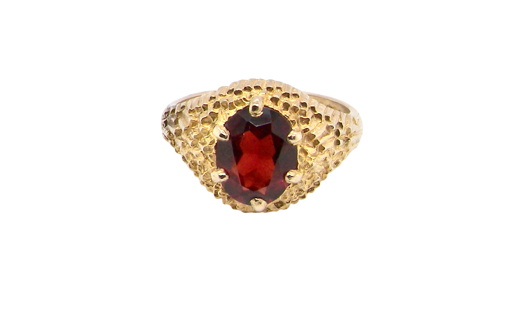 A 1970s dress ring set with an oval garnet stone. This measures 10x8mm and claw set.