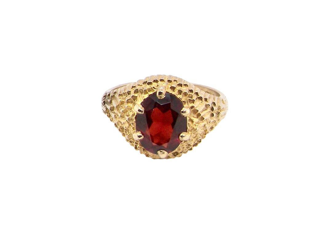 A 1970s dress ring set with an oval garnet stone. This measures 10x8mm and claw set.