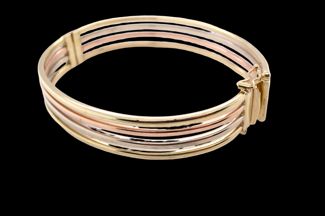 A 9 carat gold bangle with bands of rose, yellow and white gold