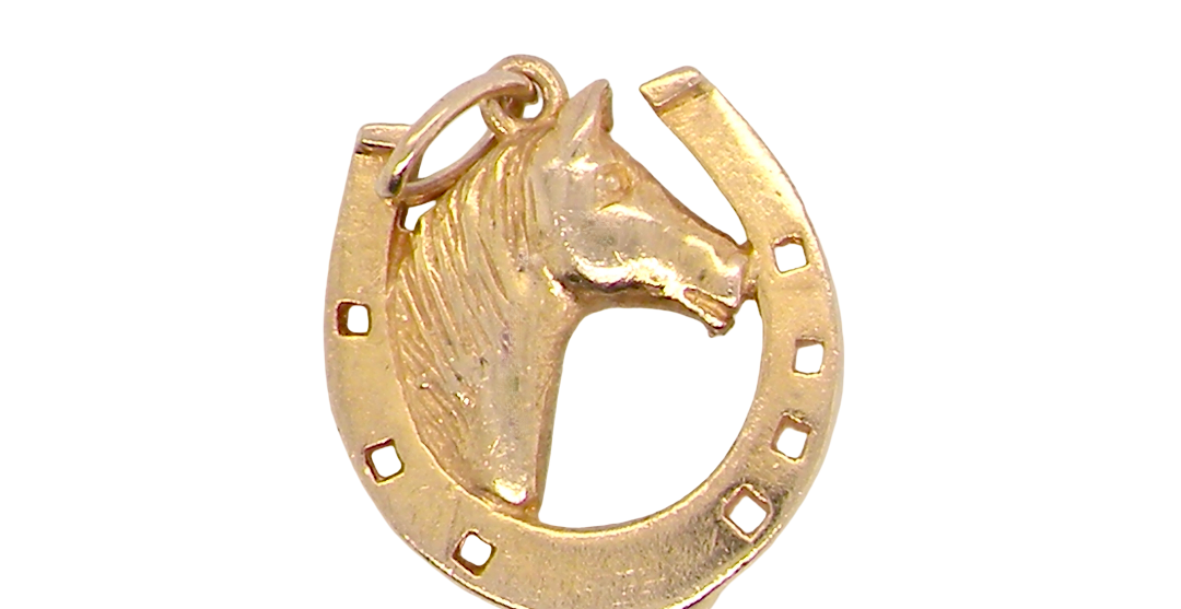 A 9 carat gold charm in the shape of a horseshoe with a horses head