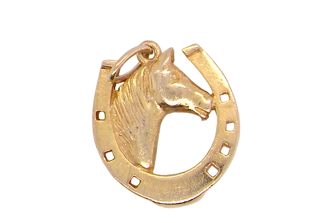 A 9 carat gold charm in the shape of a horseshoe with a horses head