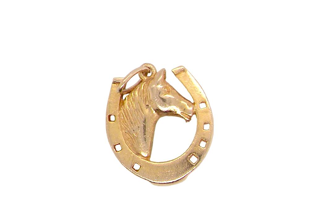 A 9 carat gold charm in the shape of a horseshoe with a horses head profile to the centre.