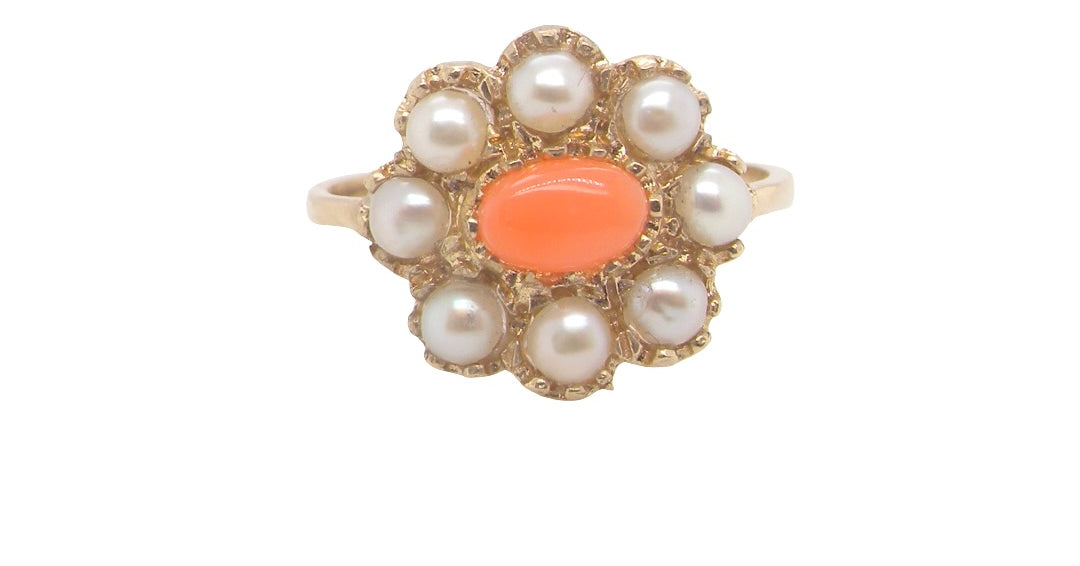 A 9 carat gold cluster ring. Centre stone an oval shaped coral stone