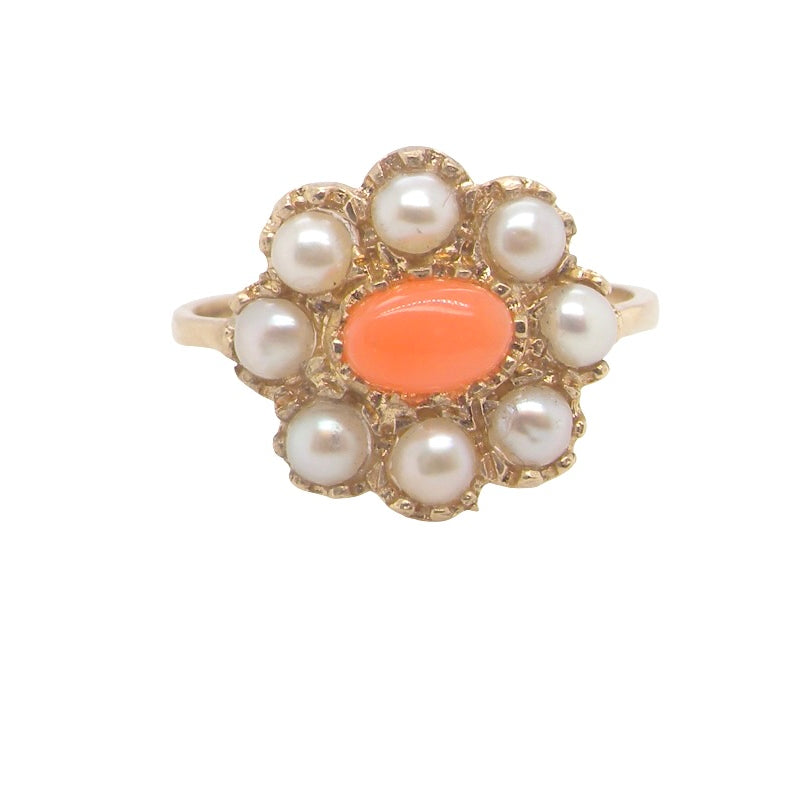 A 9 carat gold cluster ring. Centre stone an oval shaped coral stone