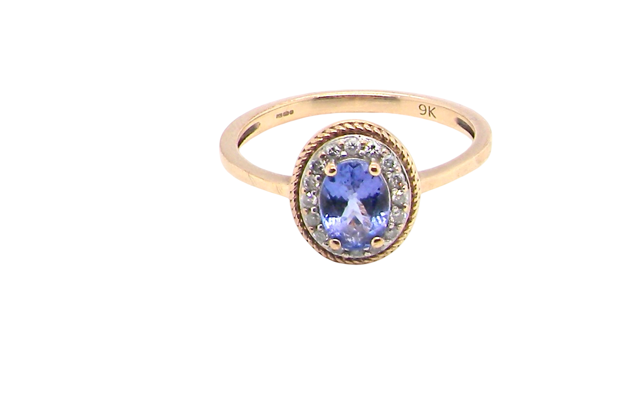 A 9 carat gold cluster ring. Features to the centre an oval cut tanzanite gem stone. Measures 7x5mm,