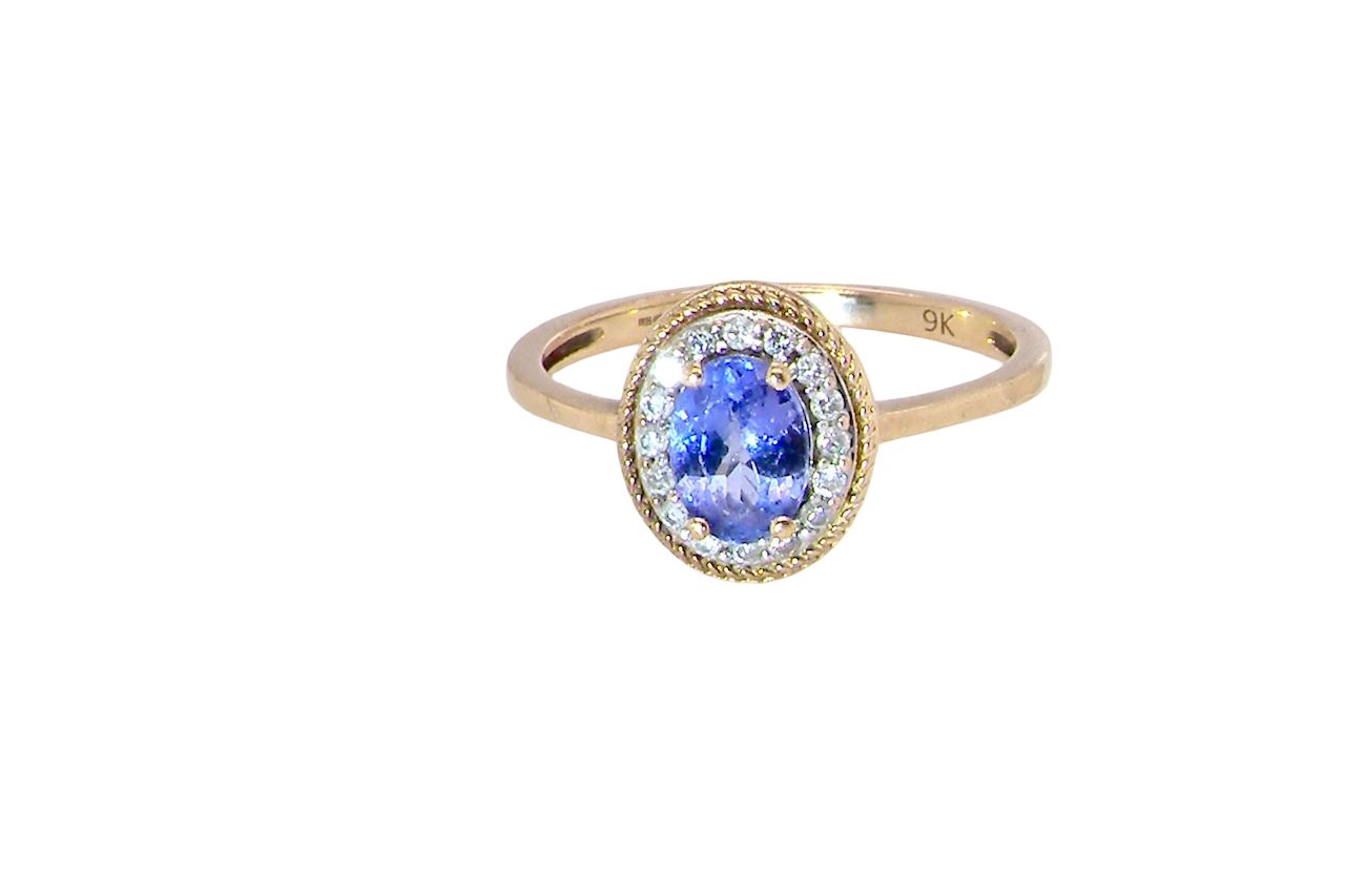 A 9 carat gold cluster ring. Features to the centre an oval cut tanzanite gem stone. Measures 7x5mm, four claw setting.