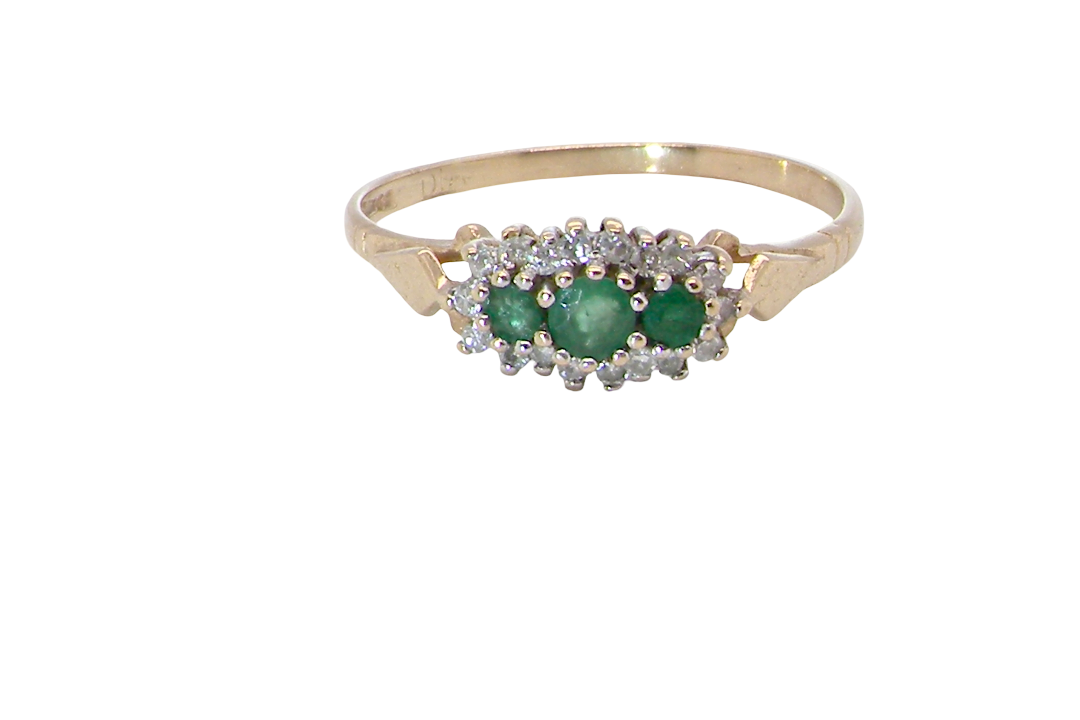 A 9 carat gold cluster ring. Set to the centre three round emeralds, centre 3.2mm,