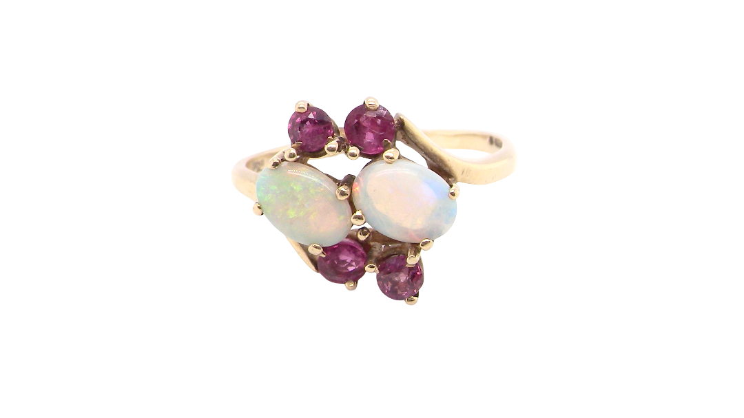 A 9 carat gold dress ring that features two oval white opals, each 7x5mm, and four rubies