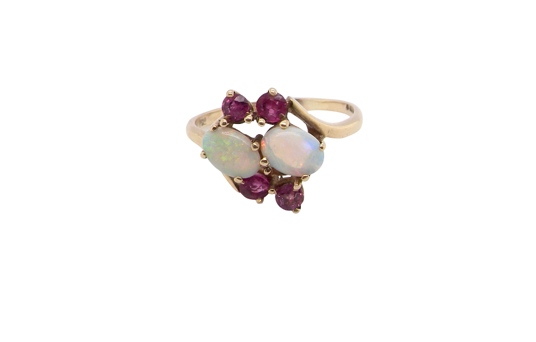 A 9 carat gold dress ring that features two oval white opals, each 7x5mm, and four rubies each 3.4mm.
