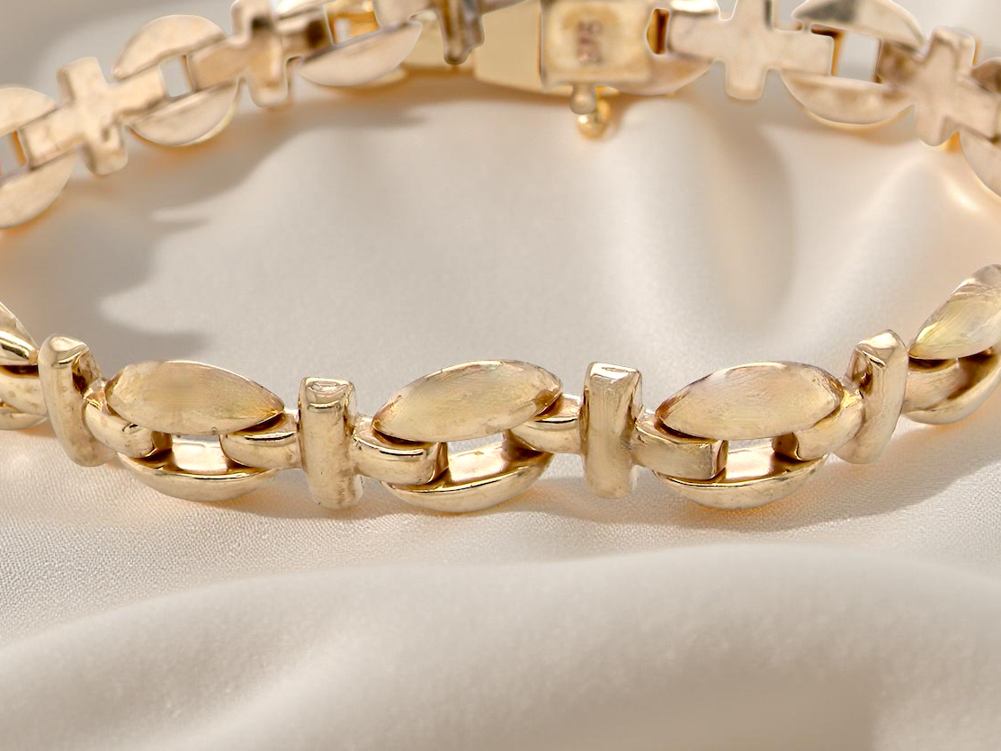 Gold bracelet on a light fabric background