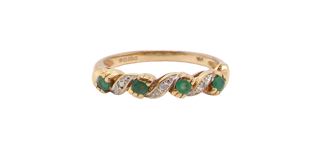 A 9 carat gold half hoop eternity ring. Set with four 2.4mm emeralds.
Set in alternate sections, a 'lazy S' design,