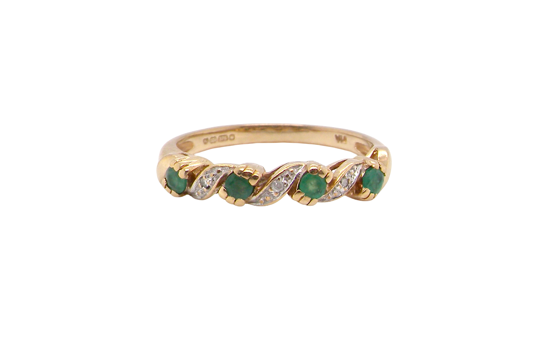 A 9 carat gold half hoop eternity ring. Set with four 2.4mm emeralds.
Set in alternate sections, a 'lazy S' design,