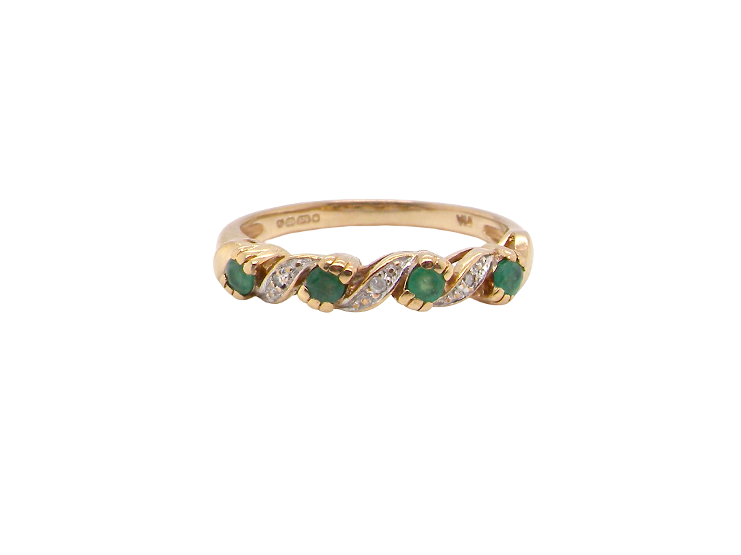 A 9 carat gold half hoop eternity ring. Set with four 2.4mm emeralds.
Set in alternate sections, a 'lazy S' design,