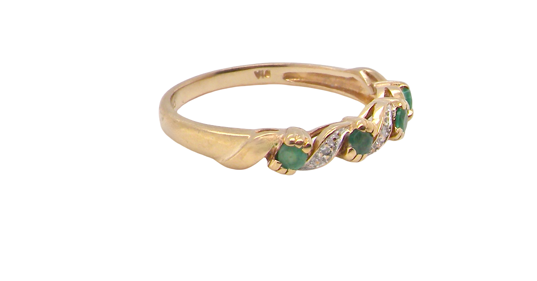A 9 carat gold half hoop eternity ring. Set with four 2.4mm emeralds.
Set in alternate sections, a 'lazy S' design, side