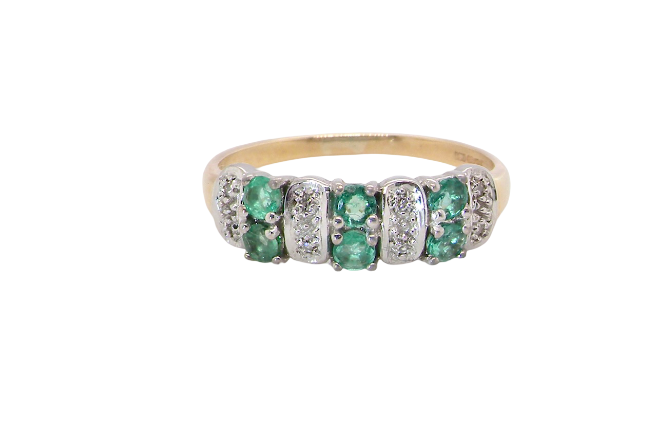 A 9 carat gold half hoop ring. Set with six round emeralds 3mm each,(total 0.35 carats est) and interspaced with vertical white gold sections each set with 1mm diamonds