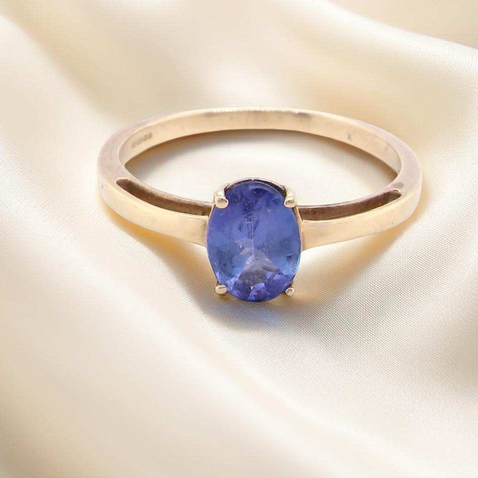 A 9 carat gold ring containing a single oval cut tanzanite gemstone, four claw setting.