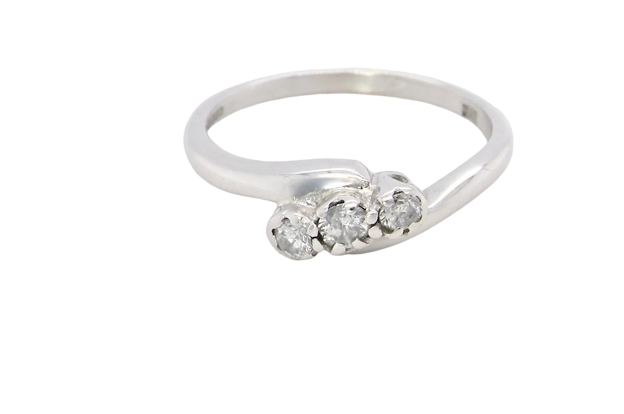 A 9 carat white gold cross over style trilogy ring. Three x 0.10mm diamonds,
