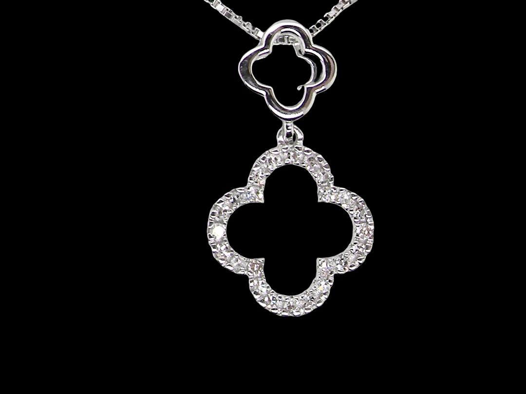 A 9 carat white gold pendant in the 'Alhambra' style. Set with twenty four small diamonds, carat total 0.12 carats.