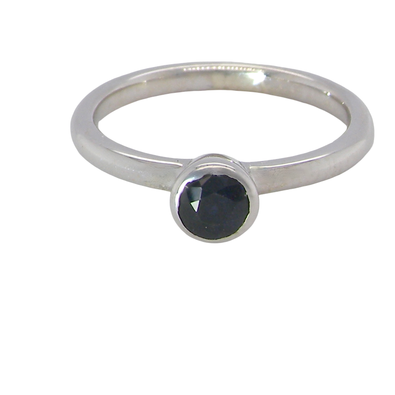 A 9 carat white gold solitaire ring. Features a round dark blue sapphire, 4.6mm diameter (Rim set.