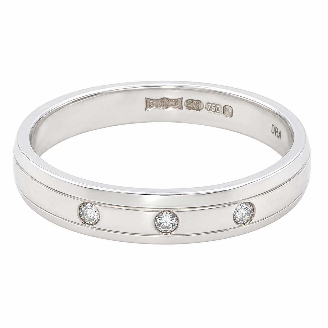 band ring with three small round-cut clear gemstones set in a row, photographed on a clean white background.
