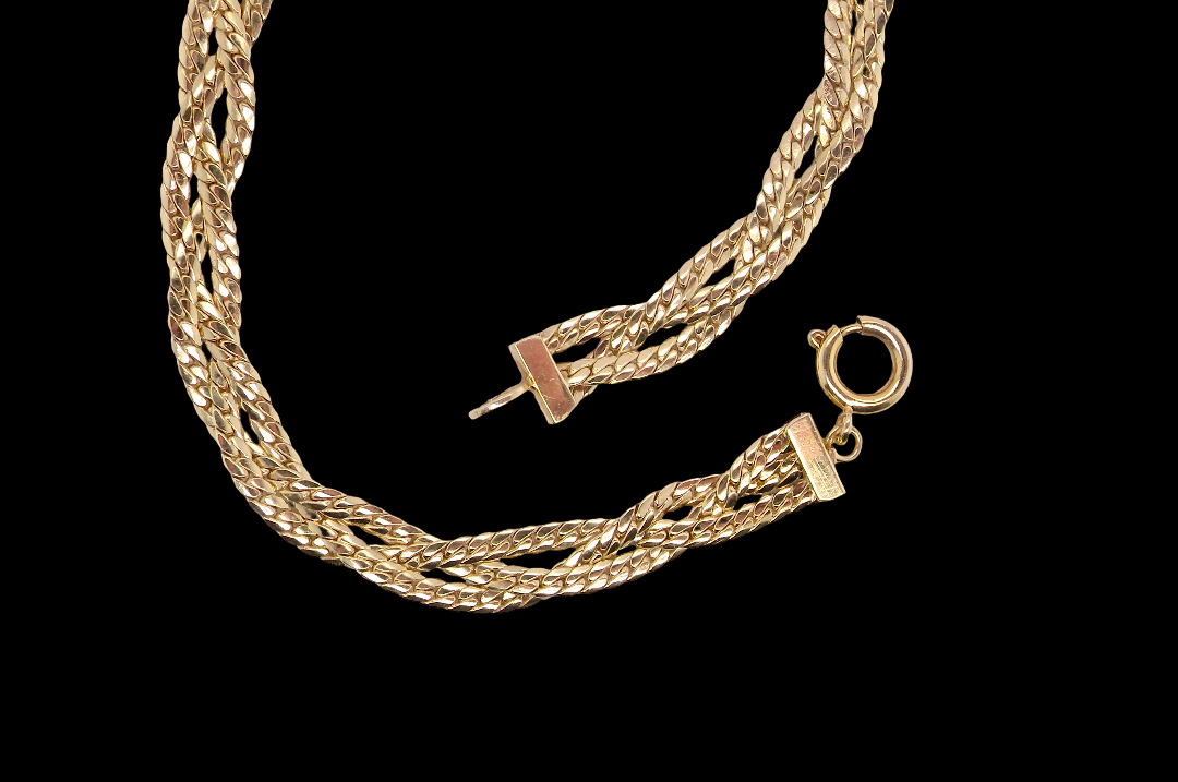 A 9 carat yellow gold bracelet. Plait design of two flat herringbone strands that weave