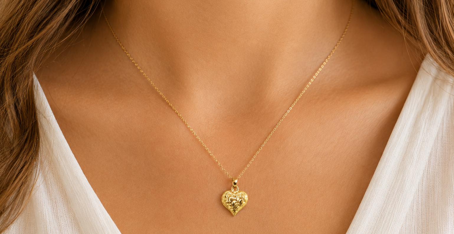 A 9ct gold patterned heart pendant on female