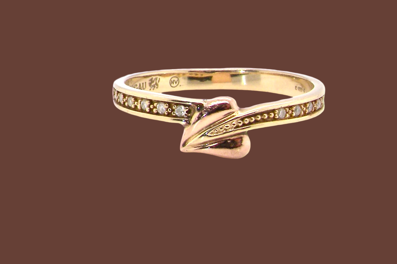 A Clogau ring which has set into the band twelve small white diamonds,