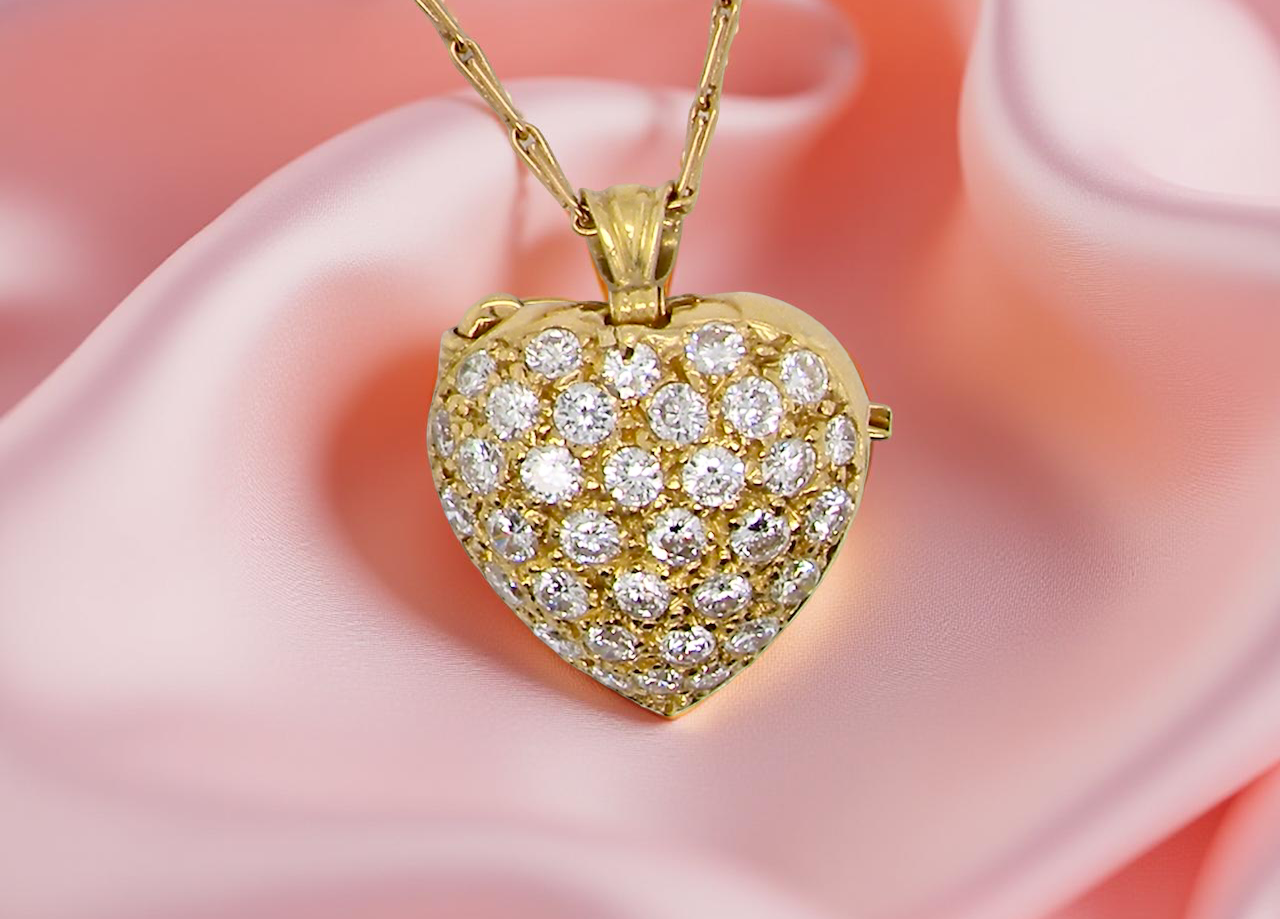 Gold heart-shaped pendant with diamonds on a pink fabric background