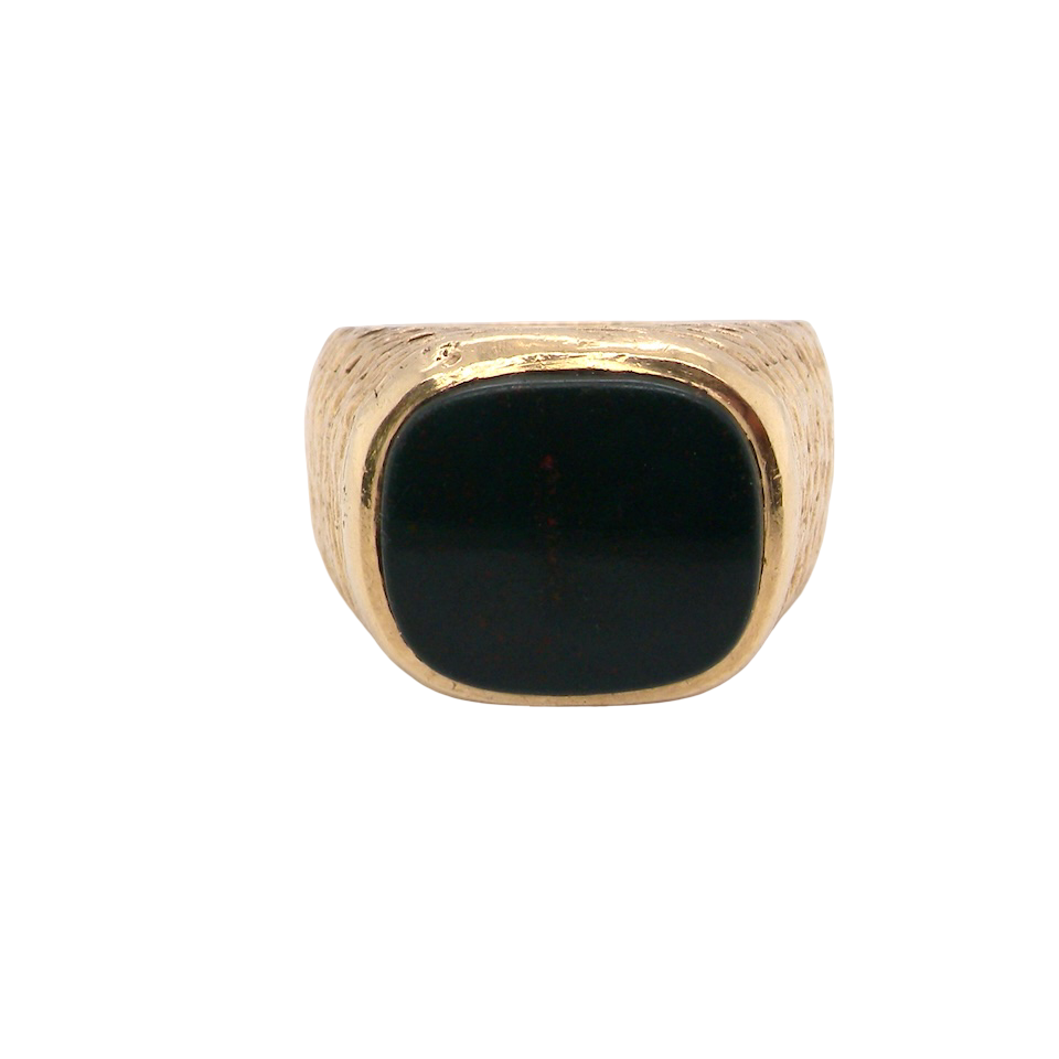 Gold ring with a black stone on a white background