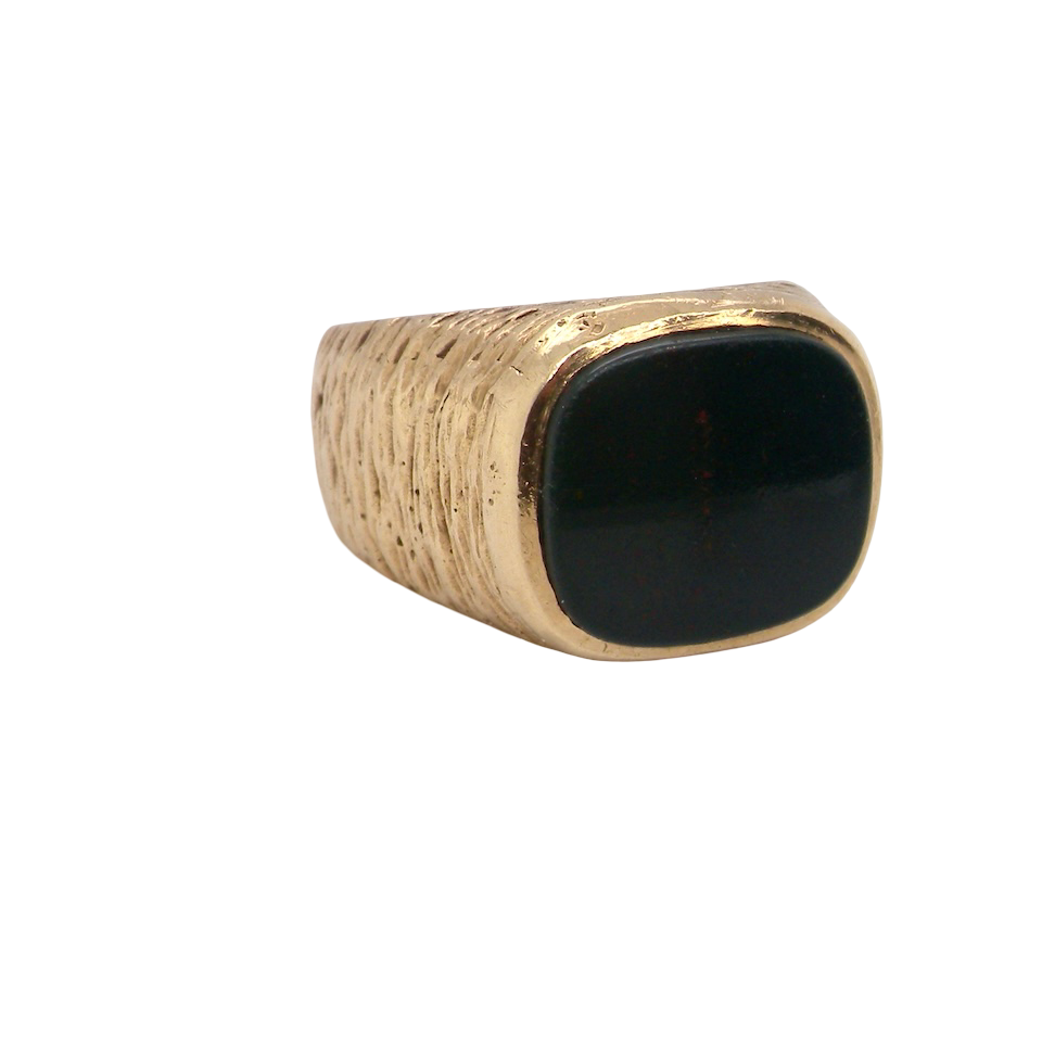 Ring with a black stone and gold band on a white background