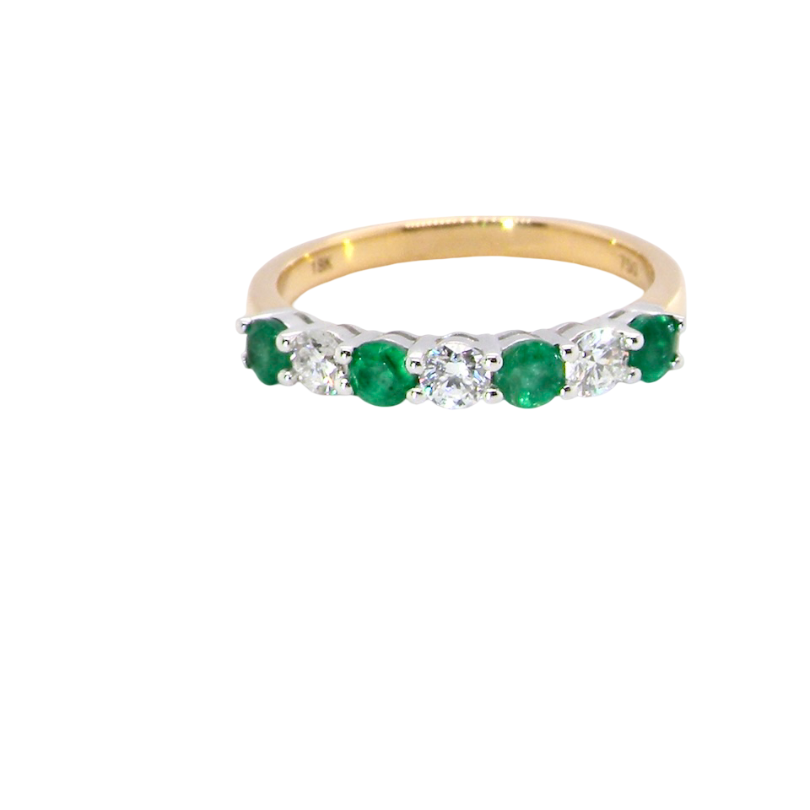 A NEW seven stone half hoop eternity ring. Set with four round emeralds, each 2.8mm (total 0.40 carats)
