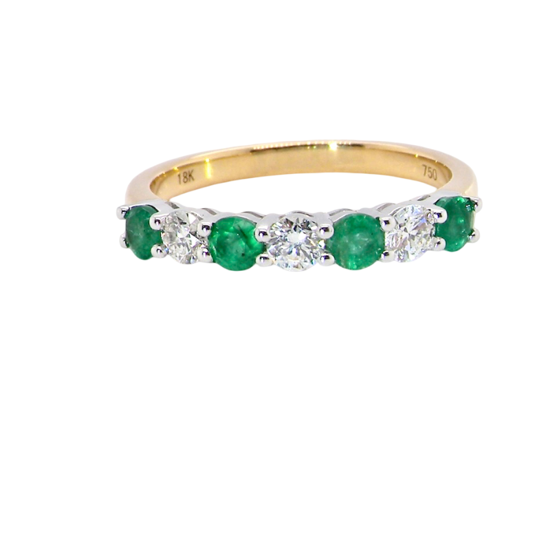 A NEW seven stone half hoop eternity ring. Set with four round emeralds, (total 0.40 carats)