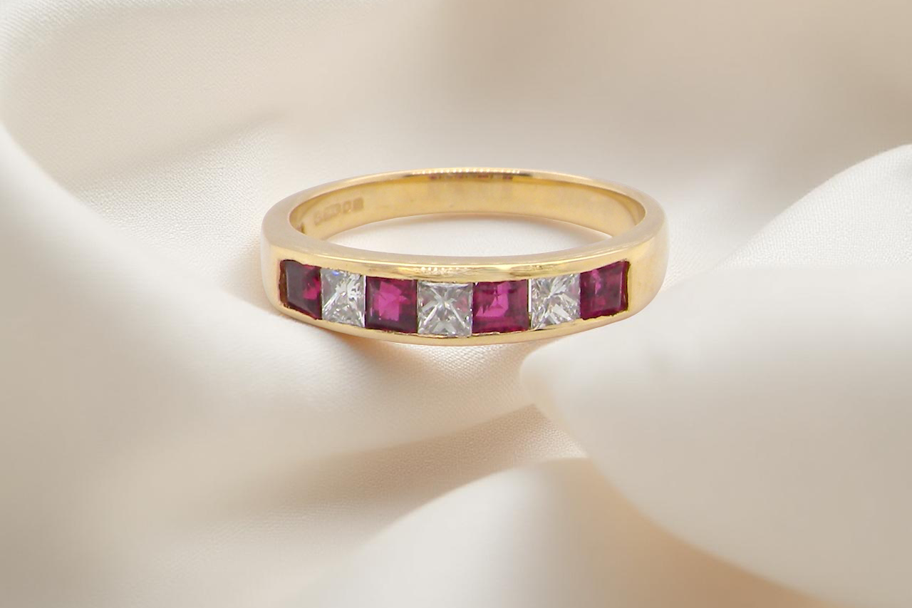A beautiful gold half-hoop eternity ring with alternating rubies and diamonds.